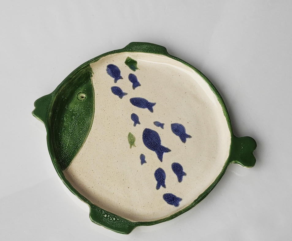 Modelovaný talíř ve tvaru ryby glazovaný houbičkovou technikou v barvách žluto-zelené a sytě tmavě zelené a modré.