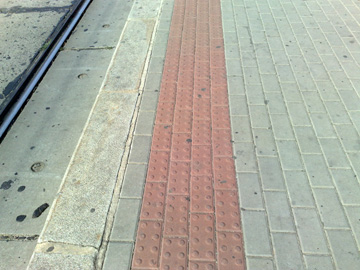 Obrzek varovnho psu z erven relifn dlaby na tramvajovm ostrvku